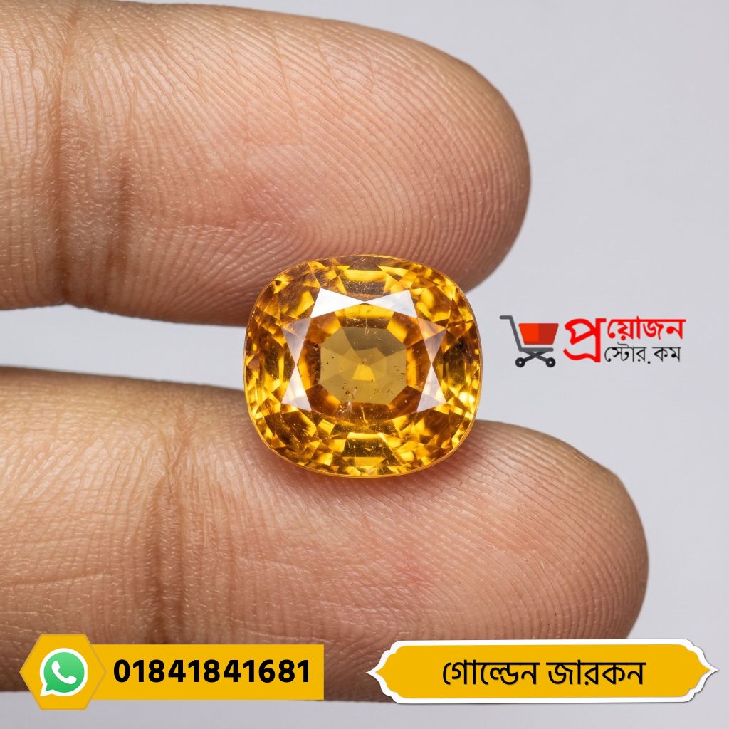 Macro close-up of a sparkling brilliant cushion-cut golden yellow natural Zircon gemstone held between fingers by Proyojonstore