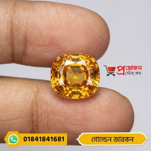Macro close-up of a sparkling brilliant cushion-cut golden yellow natural Zircon gemstone held between fingers by Proyojonstore