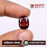 Fingertips holding a faceted oval brilliant-cut deep reddish-brown natural African Gomed gemstone by Proyojonstore