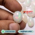Close-up of an oval natural Australian Opal gemstone with vibrant sparkling green and pink fire held in hand by Proyojonstore