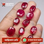 Multiple faceted oval and rectangle cut deep red African Ruby gemstones displayed on an open hand by Proyojonstore