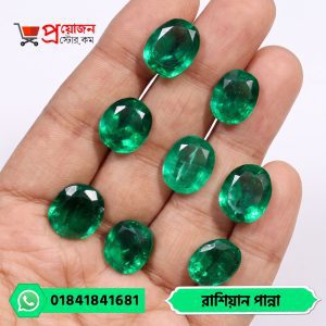 Array of eight sparkling faceted oval natural Russian Emerald gemstones displayed on an open hand by Proyojonstore
