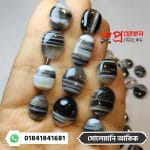 Array of oval and pillow cut banded Solemani Akik gemstones placed along open fingers by Proyojonstore