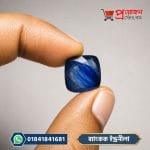 Cushion-cut Bangkok Blue Sapphire Stone held between fingers