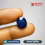Bangkok Blue Sapphire Stone (ব্যাংকক ইন্দ্রনীলা রত্নপাথর) held between fingers