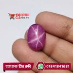 Close-up of a smooth high-dome oval magenta-pink natural Bangkok Star Ruby gemstone with sharp 6-ray asterism held between fingertips by Proyojonstore