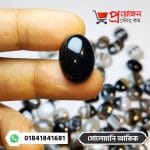 Close-up of a smooth glossy solid black Solemani Akik gemstone held between fingertips by Proyojonstore