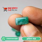 Close-up of a classic emerald cut rectangular green Brazilian Emerald gemstone held with fingers by Proyojonstore