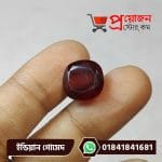 Macro view of a sparkling square-cushion faceted deep brown-red natural Indian Gomed gemstone held between fingertips by Proyojonstore