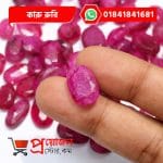 Close-up of a sparkling transparent faceted oval pink-magenta natural Karu Ruby gemstone held between fingertips over loose gems by Proyojonstore