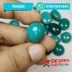 Close-up of a smooth round polished natural blue-green Feroza Turquoise gemstone held between fingertips by Proyojonstore