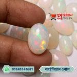 Detailed macro view of a luminous oval Australian Fire Opal gemstone displaying radiant orange, yellow, and green fire held between fingertips by Proyojonstore