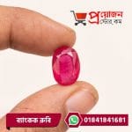 Macro view of a vibrant oval faceted pink-red natural Bangkok Ruby gemstone held between fingertips by Proyojonstore