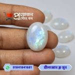 Close-up of a high-clarity oval natural Srilankan Blue Moonstone gemstone with blue-rainbow sheen held between fingertips by Proyojonstore