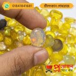 Detailed macro view of a translucent faceted oval Ceylon Sapphire gemstone displaying subtle fiery glowing colors held in hand by Proyojonstore