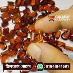 Fingertips holding a faceted square step-cut golden-honey natural Srilankan Gomed gemstone over loose stones by Proyojonstore