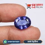 Vivid deep blue oval Marca Sapphire gemstone held between fingers - Proyojonstore