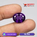 Vivid deep violet oval cut Poddo Nila Amethyst gemstone held between fingers - Proyojonstore