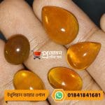 Five polished natural orange Ethiopian Fire Opal gemstone cabochons displayed on an open hand by Proyojonstore