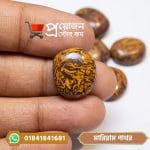 Close-up of a premium oval cut natural Mariam calligraphy gemstone held between fingers by Proyojonstore