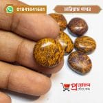 Single round polished natural Mariam stone (মারিয়াম পাথর) held with fingers by Proyojonstore