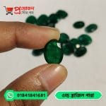 Macro view of a high-grade oval faceted rich green natural Old Brazil Emerald gemstone held between fingertips by Proyojonstore